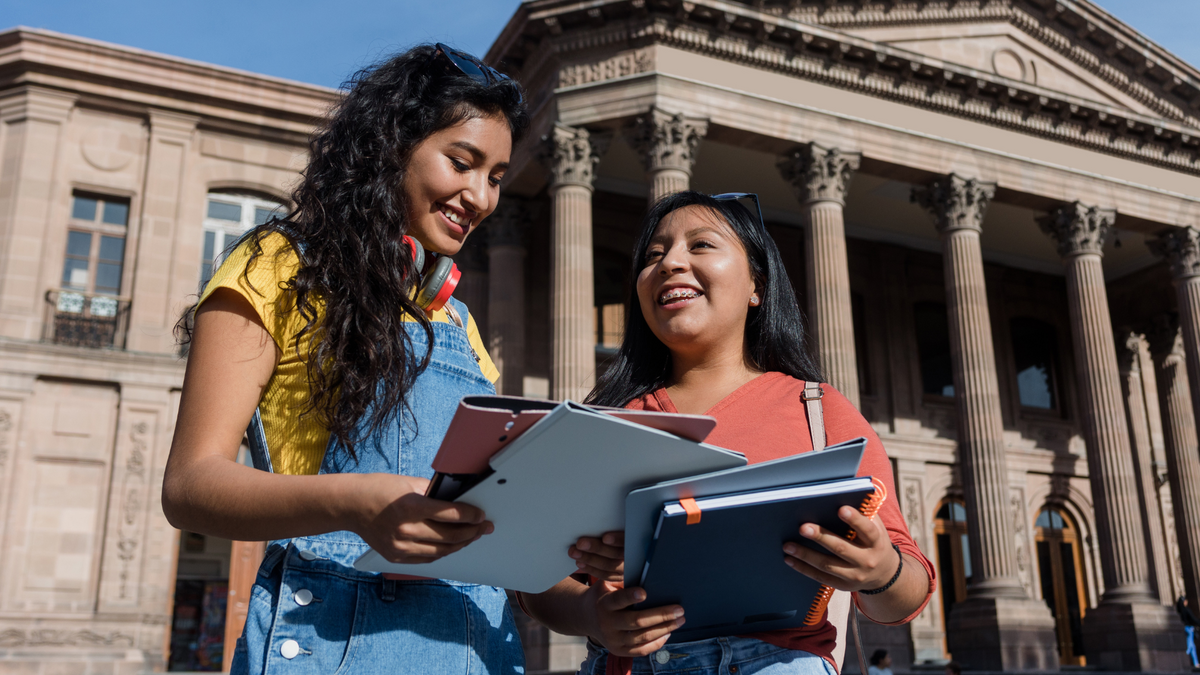 two students reading a document and smiling